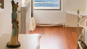 A room with a large arched window overlooking a body of water and a boat.