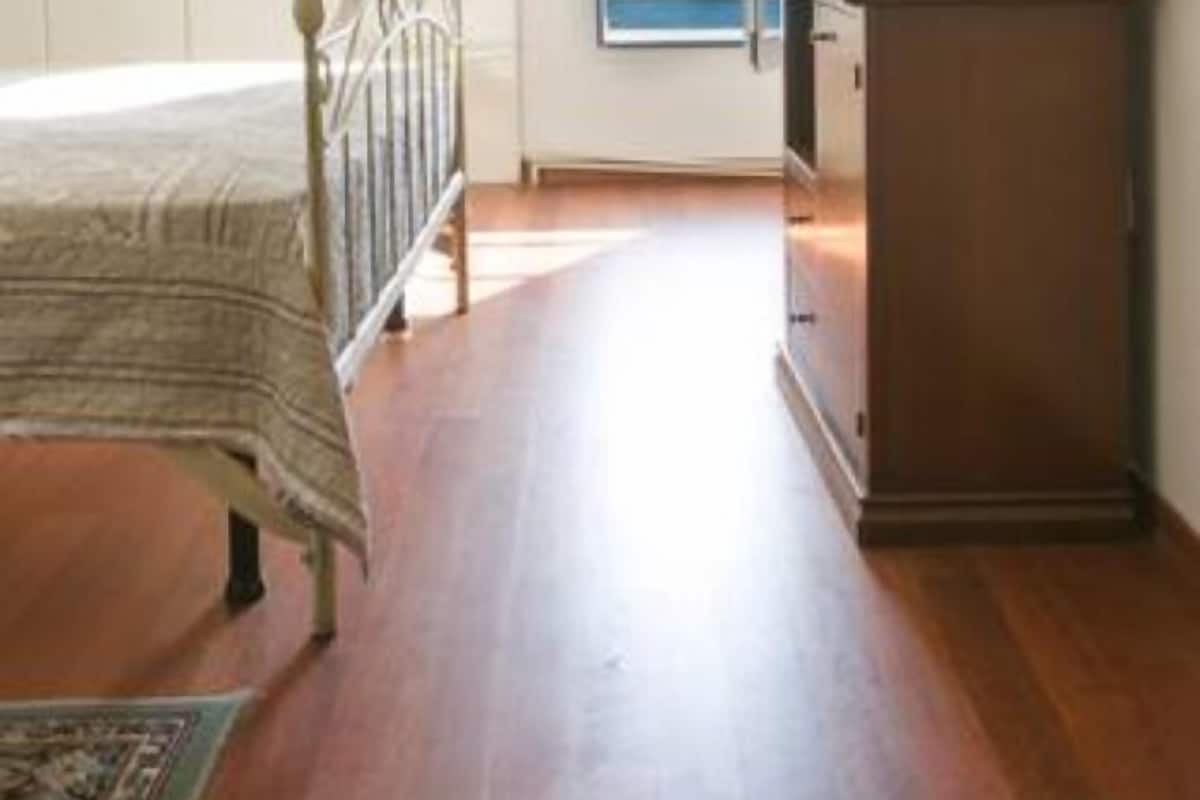 Une chambre à coucher avec un lit, une télévision, une armoire et une vue sur la mer par la fenêtre.