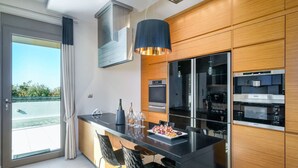 A modern kitchen with a large island, built-in appliances, and a view of the outdoors.