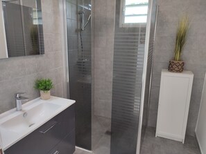Regadera, secadora de cabello, toallas, papel de baño 
