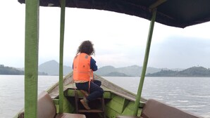 A boat with wooden benches and a covered area. -  LEISURE INN (Muhoza)