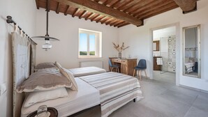 Un dormitorio con cama, escritorio, silla y espejo.