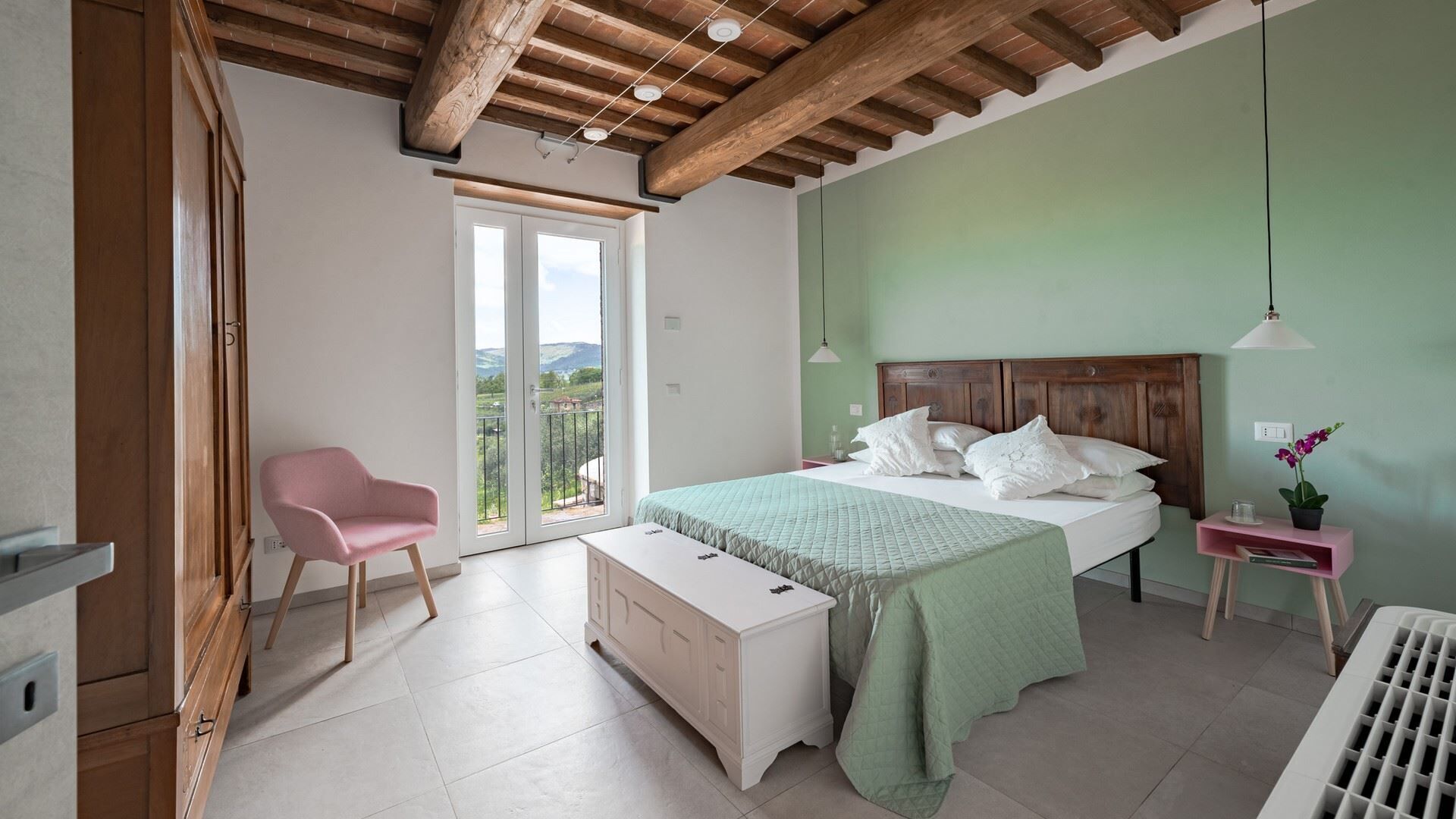 Une chambre à coucher comprenant un lit, une chaise, une table de chevet et une vue sur l’extérieur.
