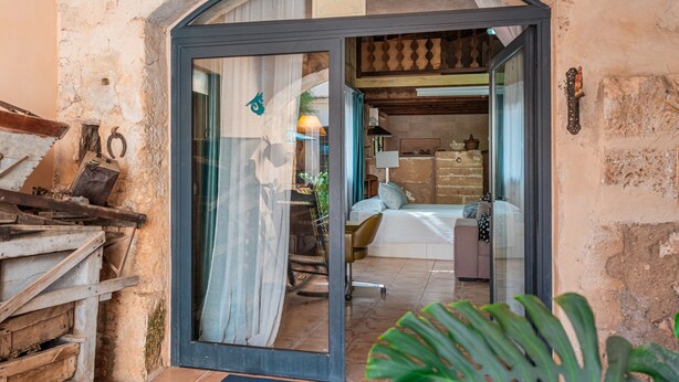 An arched doorway leading into a room with a bed, a chair, and a table. - Apartment "Segles 11" with Shared Pool & Wi-Fi (Campos)