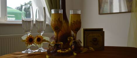 A table with three glasses of a yellow beverage, a decorative bottle, and a framed certificate.