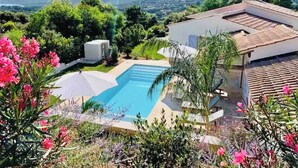 Una proprietà residenziale con piscina, immersa nel verde e con vista sulle montagne lontane.
