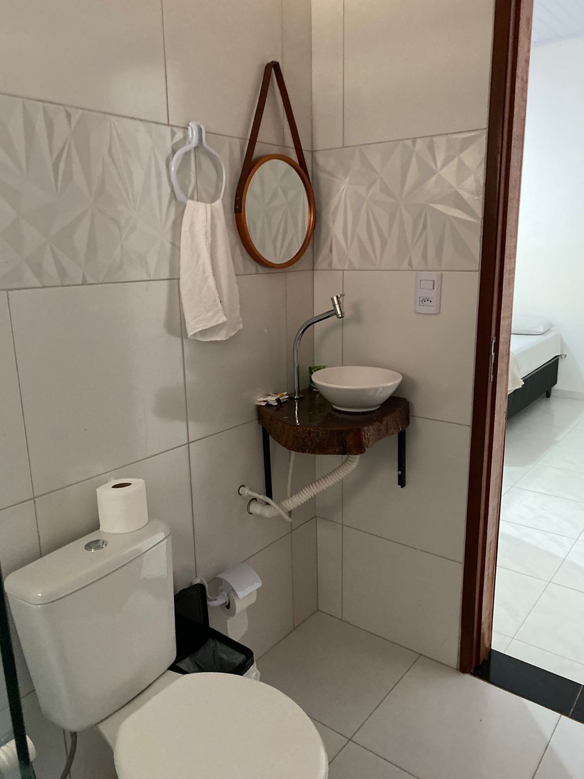 A small bathroom with a toilet, sink, and mirror.