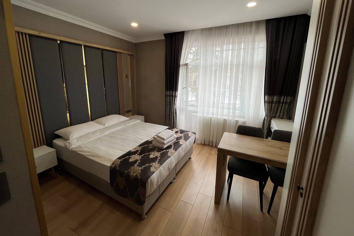 Una camera d'albergo con un letto grande, una scrivania e una sedia.