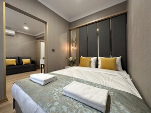 Una camera d'albergo moderna con un letto grande, un divano e uno specchio.
