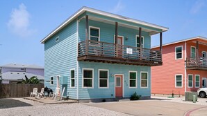 A two-story house with a balcony, a front door, and a garage. - Just Wanna Have Sun, Game Room, Pool & Beach (Port Aransas)