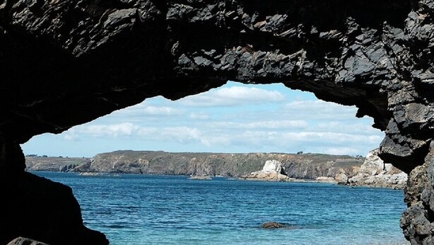 Un paisaje costero con un litoral rocoso y un mar azul cristalino.