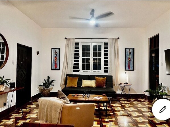 Uma sala de estar com sofá, mesa de centro e piso estampado.