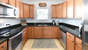 A kitchen with wooden cabinets, a stainless steel microwave, a double oven, a sink, and a coffee maker. - 4 Bedroom Beach House with Shared Pool in Surfside Beach! The Ville (Surfside Beach)