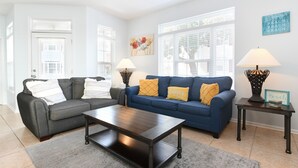 A living room with a dark wood coffee table, two sofas, and a rug. - 4 Bedroom Beach House with Shared Pool in Surfside Beach! The Ville (Surfside Beach)