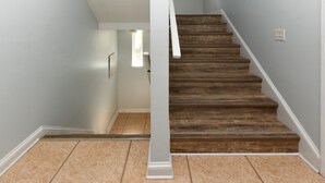 A staircase with wooden steps and a white column. - 4 Bedroom Beach House with Shared Pool in Surfside Beach! The Ville (Surfside Beach)