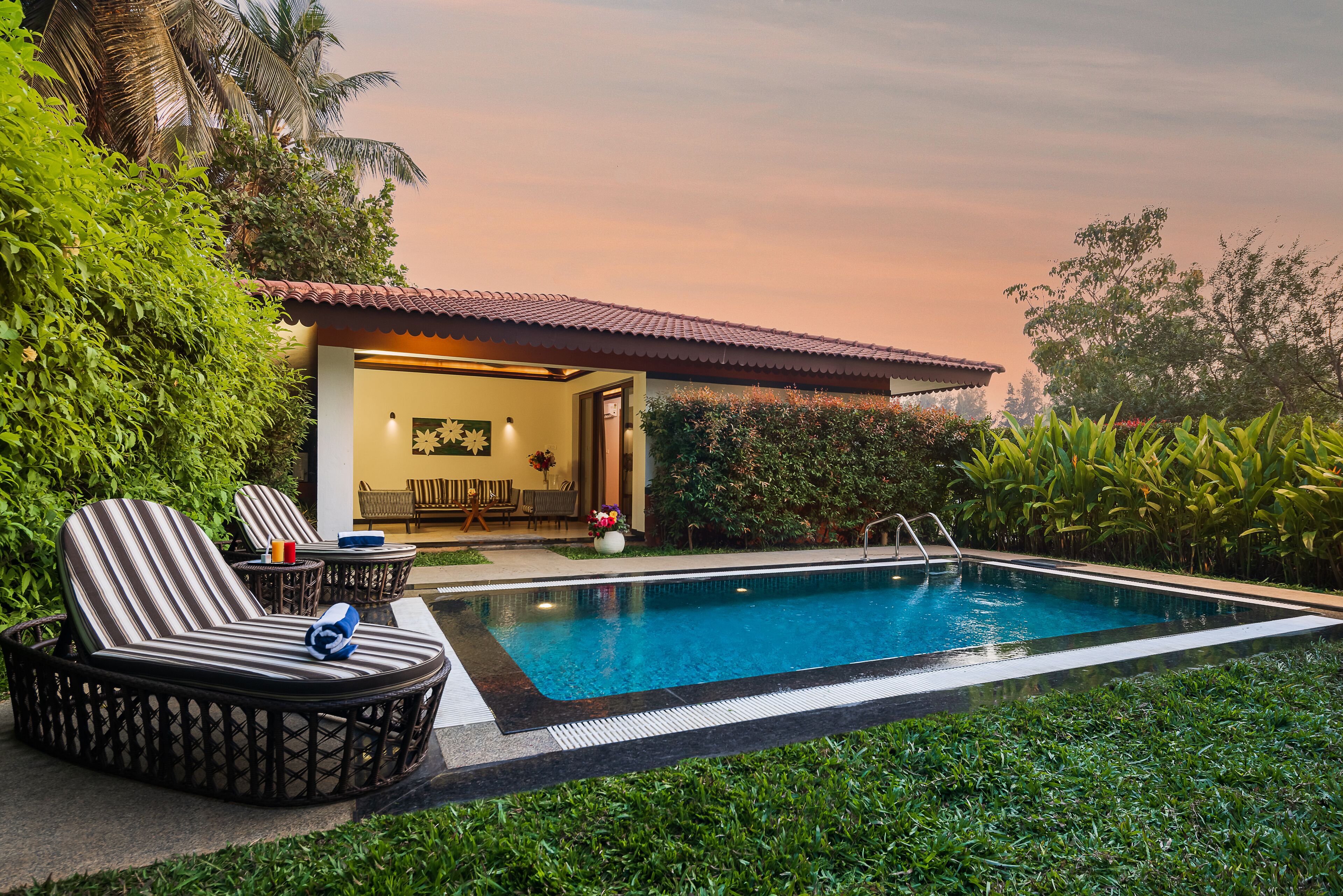 A swimming pool with lounge chairs and a dining area.
