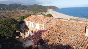 Un edificio costero con techo de tejas que da a una playa y al mar.