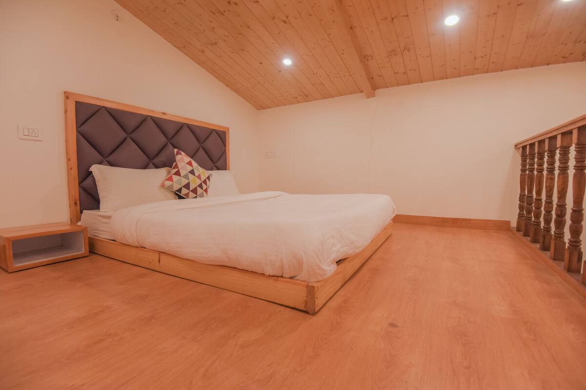 A bedroom with a wooden bed frame, a headboard, and a nightstand.