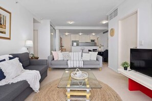 Relax in this stylish living room with a sofa, coffee table, and flat-screen TV.