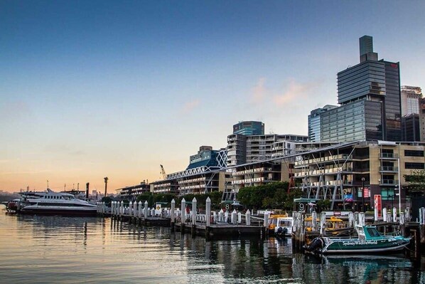 Stunning waterfront views of the city skyline and marina, with a docked yacht and mooring posts.