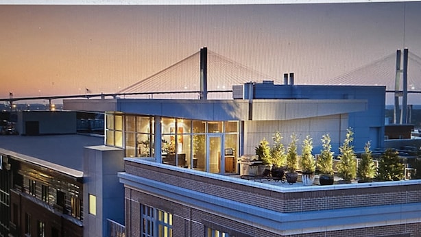 A modern building with a rooftop garden and large windows.