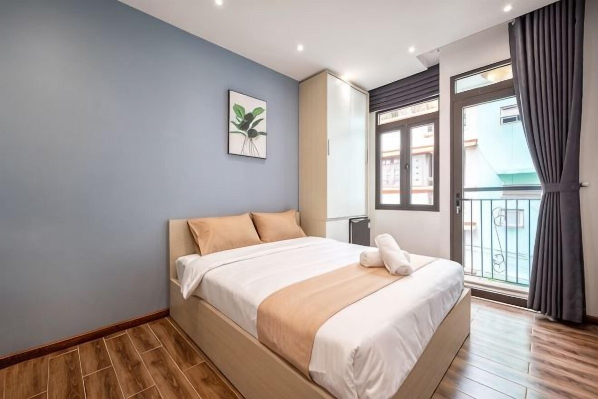Un dormitorio con cama, ventana y vista al exterior.