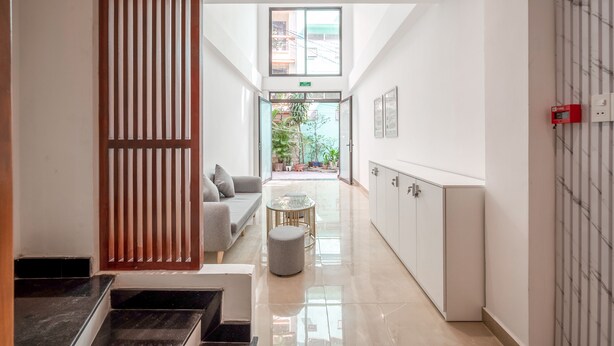 Un hall d’hôtel moderne avec un canapé, une petite table ronde et un meuble.