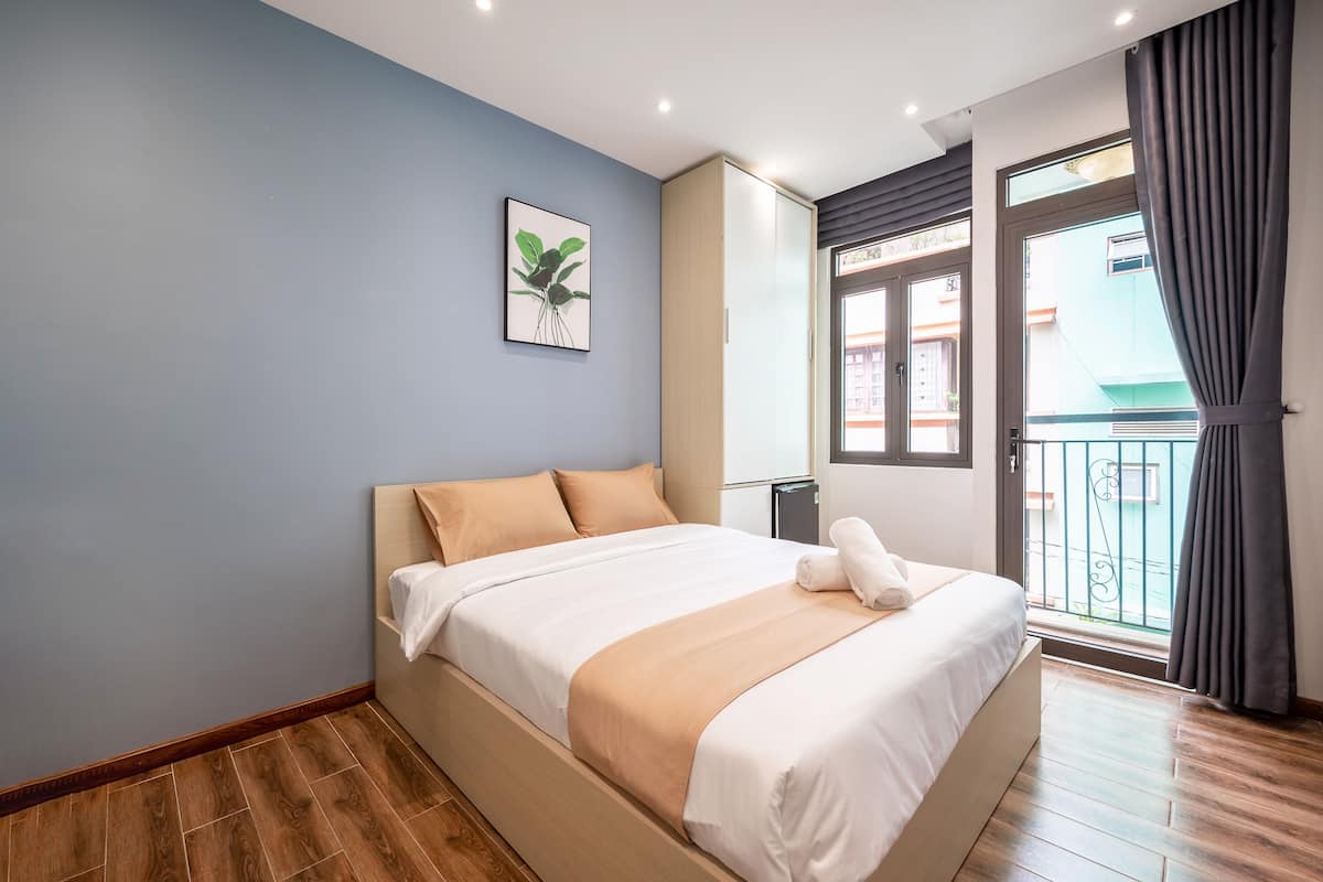 Um quarto moderno com uma cama, uma janela com vista e uma porta para uma varanda.