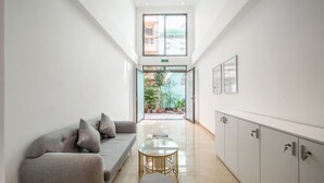 Un intérieur moderne avec un canapé, une table en verre et des meubles de rangement.