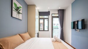 Une chambre d’hôtel avec un lit, une télévision, un tableau et une vue sur l’extérieur.