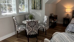 A dining area with patterned chairs, a table, and a painting on the wall.