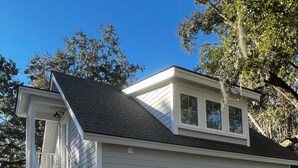 A two-story house with a covered front porch, a garage, and a driveway.