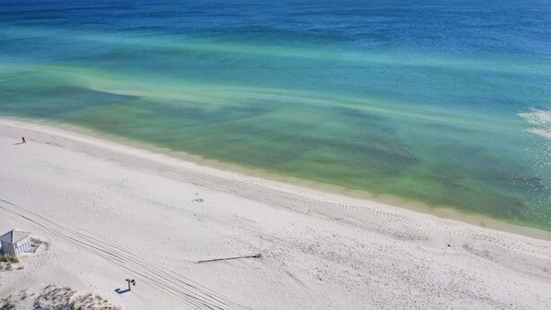 Ein Strand mit klarem türkisblauem Wasser und weißem Sand.