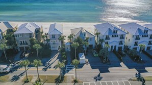 Ein Küstenhotel mit mehreren Gebäuden, einem Parkplatz und Blick auf den Strand.