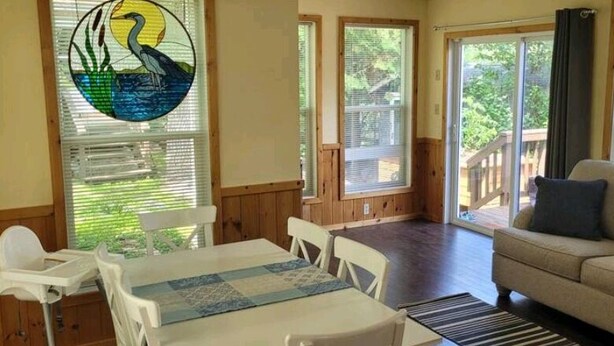 Una habitación con una mesa de comedor, sillas, un sofá y un ventanal con vistas a una terraza.