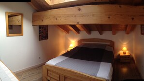 A wooden bed with a headboard, two bedside lamps, and a small wooden nightstand. - THE THREE SNAP HOOKS (Champagny-en-Vanoise)