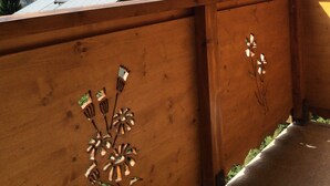 A wooden balcony with decorative metalwork, overlooking a mountainous landscape with a clear sky. - THE THREE SNAP HOOKS (Champagny-en-Vanoise)