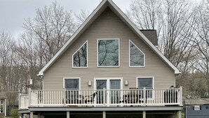 A two-story house with a balcony, a covered patio, and a garage.
