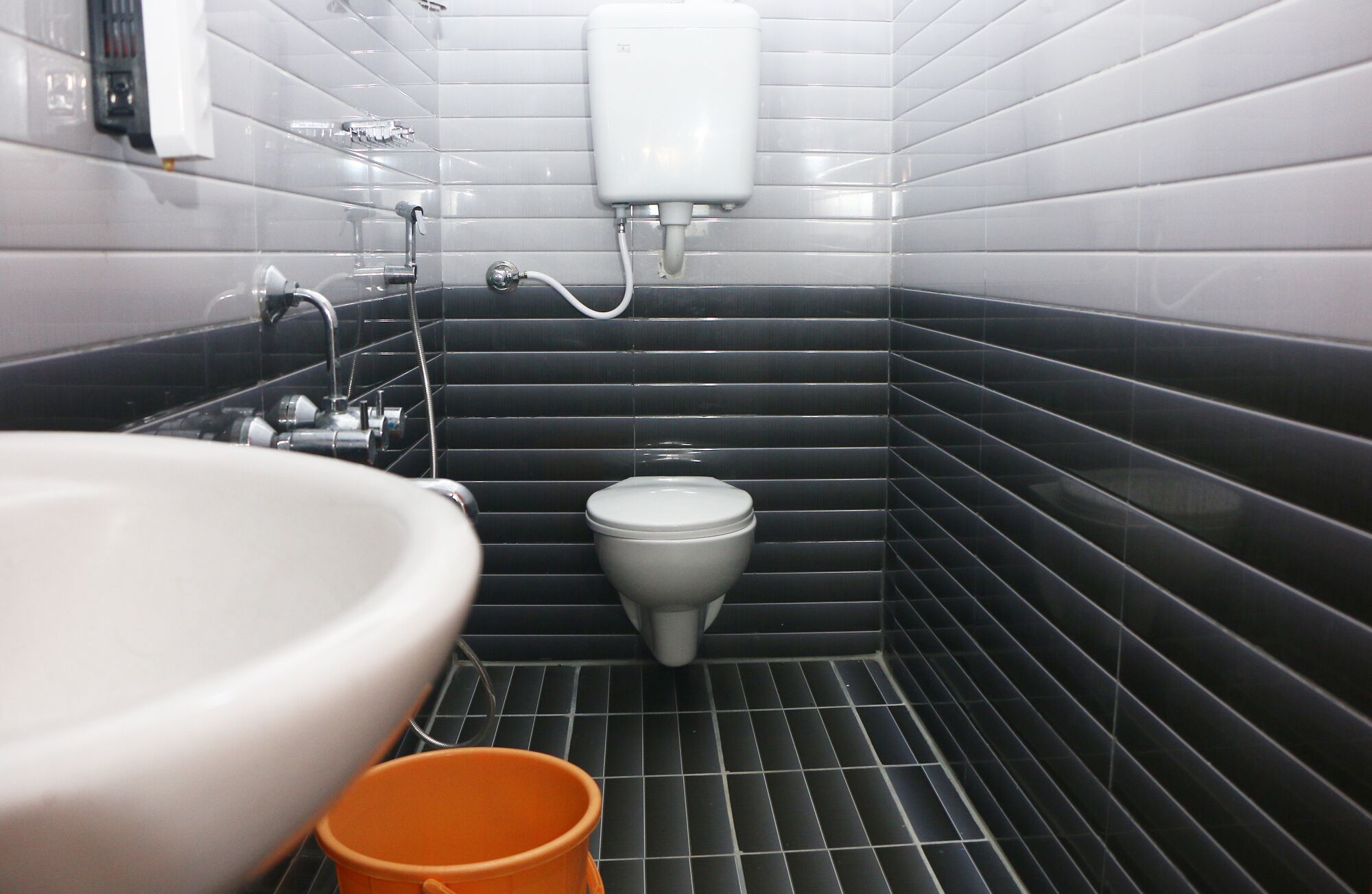 A bathroom with a toilet, sink, and a hand dryer.