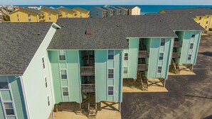 Un immeuble à plusieurs étages, doté d’un toit plat, de nombreux balcons et d’une entrée au niveau du sol.