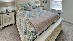 Une chambre à coucher comprenant un lit, des tables de chevet, une fenêtre et une étagère murale décorative.