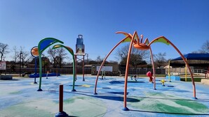 A playground with colorful play structures and a clear blue sky. - Remodeled home with firepit! 1 mile to Randolph AFB & 3 parks! (Universal City)