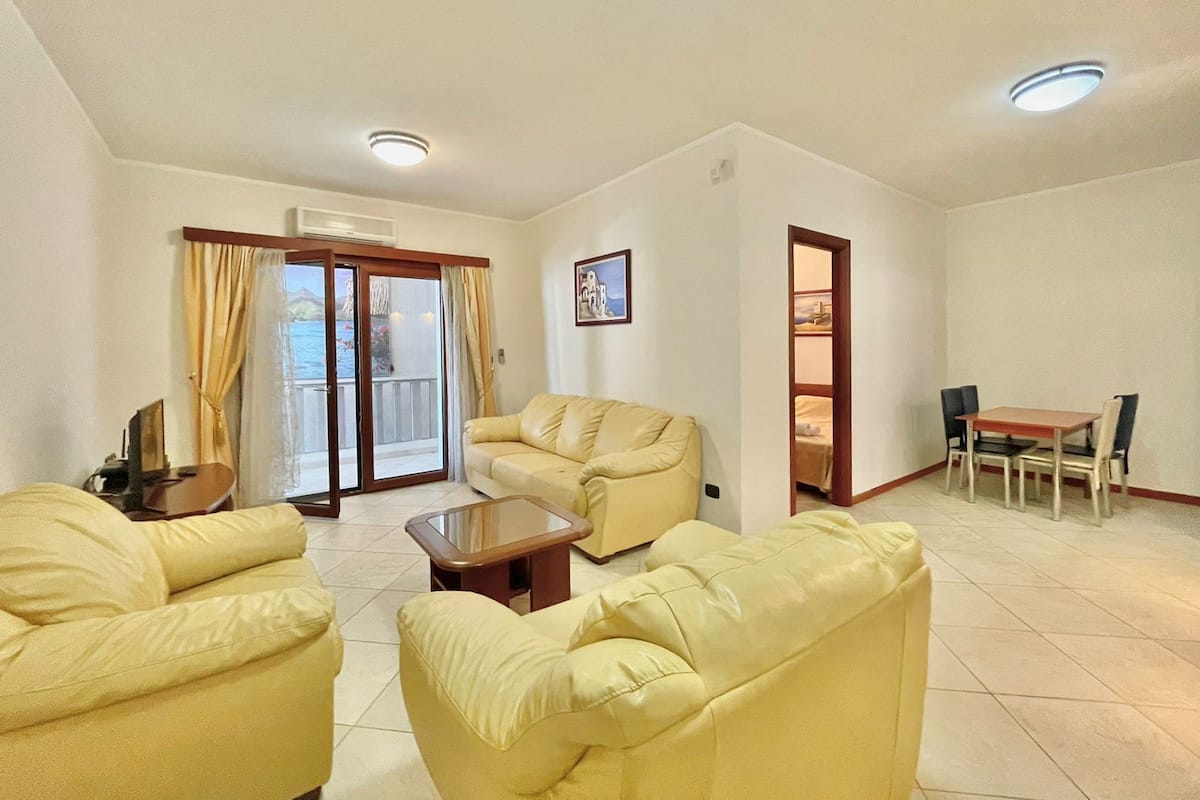 Departamento estándar, 1 habitación, vista parcial al mar | Área de sala de estar | Televisión de 70 cm con canales por cable