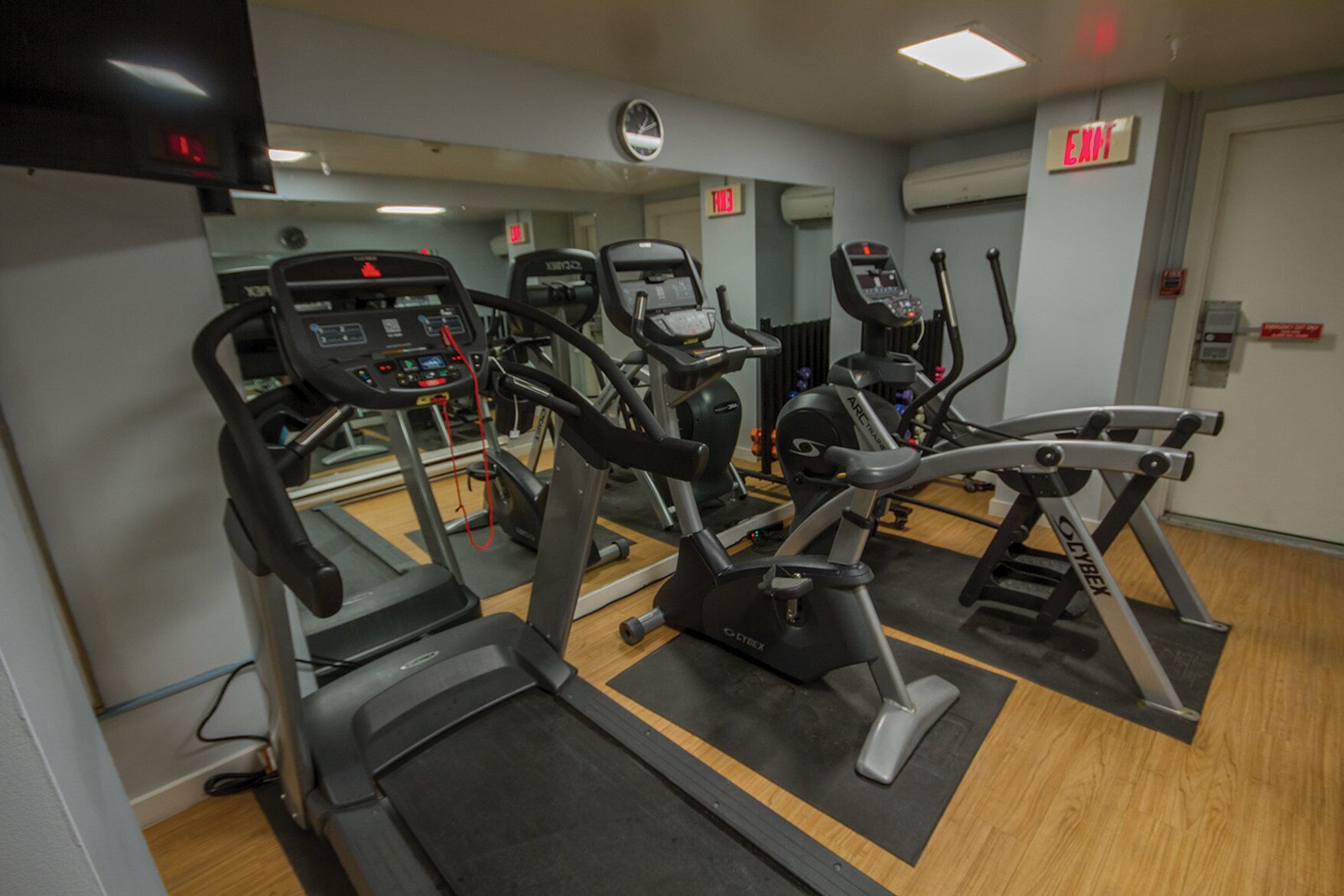 Ein Fitnessstudio mit Laufbändern, Crosstrainern und einem Ergometer.