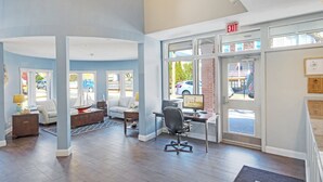 A spacious lobby with a desk, computer, and seating area.