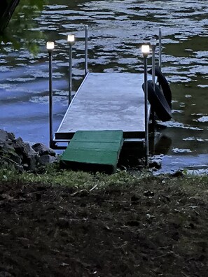 Une jetée s’avançant dans une étendue d’eau, avec une plateforme verte à son extrémité.