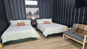 Une chambre avec deux lits, une table de chevet, une chaise et un climatiseur fixé au mur.