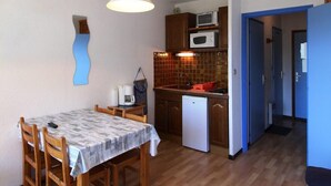 A compact kitchen with a microwave, a coffee maker, and a refrigerator. - 50m from resort center, Ground floor, view mountain, balcony, parking, ski locker, 23m² (Auris)