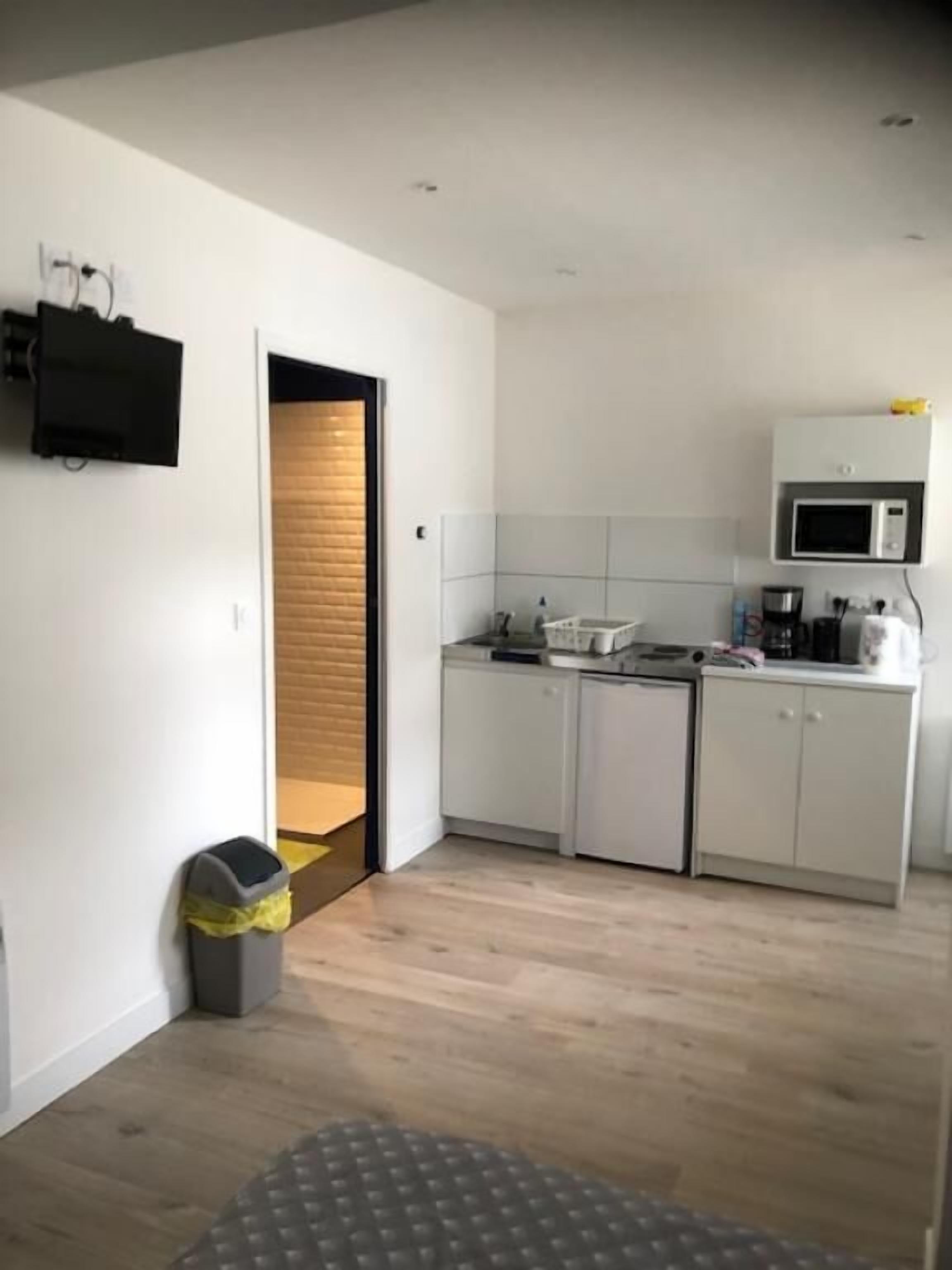 A modern kitchen with white cabinets, a microwave, and a coffee maker.