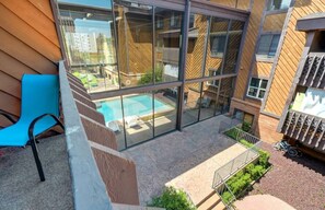 Un edificio moderno con ampie vetrate, una piscina e un'area relax all'aperto.